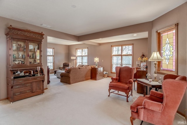 living area featuring visible vents and light carpet