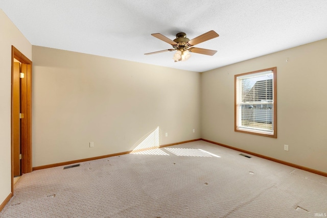 empty room featuring visible vents, ceiling fan, baseboards, carpet floors, and a textured ceiling