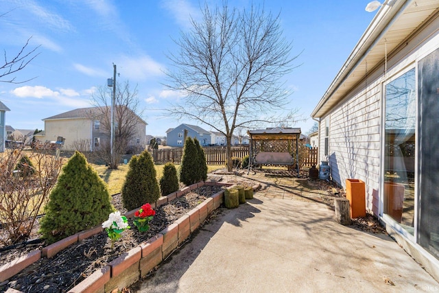 view of patio / terrace featuring a gazebo, a vegetable garden, and fence