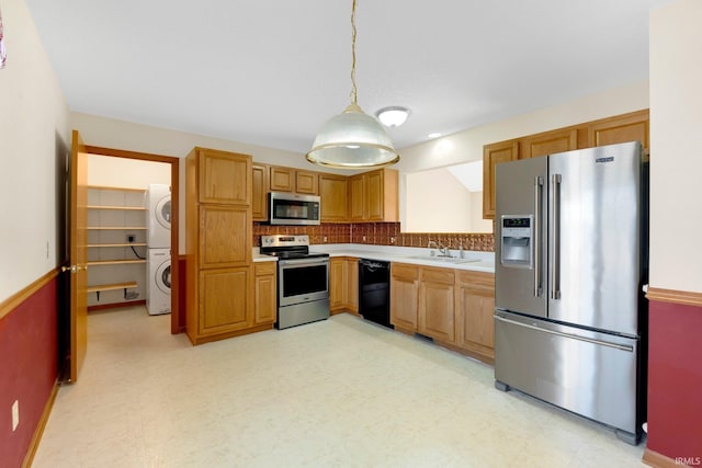 kitchen featuring light floors, appliances with stainless steel finishes, stacked washer / drying machine, and a sink