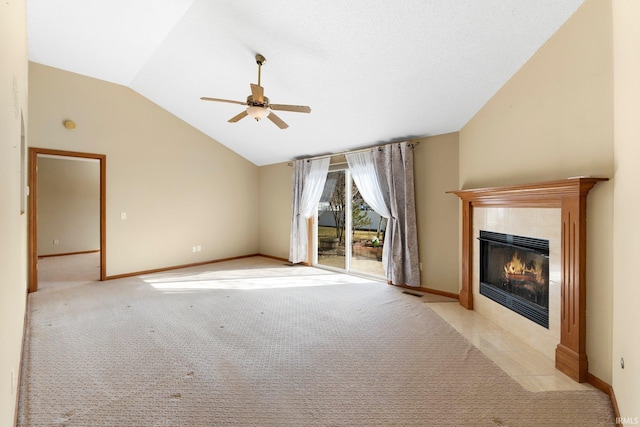 unfurnished living room with baseboards, lofted ceiling, a fireplace, ceiling fan, and light colored carpet