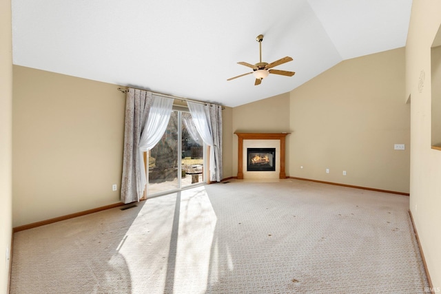 unfurnished living room with baseboards, carpet floors, a glass covered fireplace, and vaulted ceiling