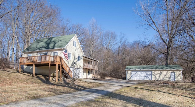 view of side of home with stairs, an outbuilding, driveway, and a wooden deck