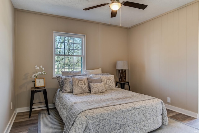 bedroom featuring ceiling fan, baseboards, and wood finished floors