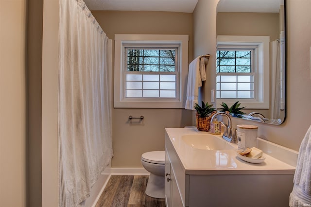 full bath featuring a shower with curtain, toilet, wood finished floors, baseboards, and vanity