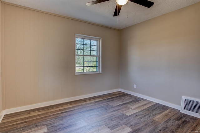 unfurnished room with wood finished floors, baseboards, visible vents, ceiling fan, and a textured ceiling