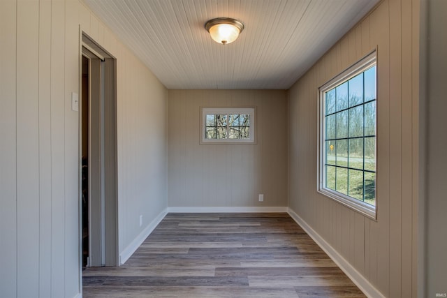 unfurnished room featuring baseboards and wood finished floors