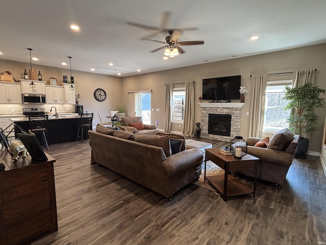 living area with dark wood-style floors, plenty of natural light, and recessed lighting