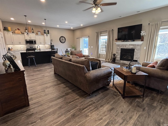 living room with a fireplace, dark wood-type flooring, recessed lighting, and a ceiling fan