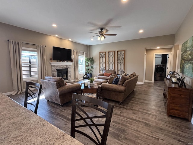 living area featuring a ceiling fan, dark wood finished floors, washer / dryer, recessed lighting, and a fireplace