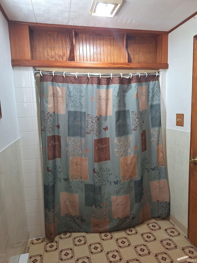 full bathroom featuring curtained shower and tile walls