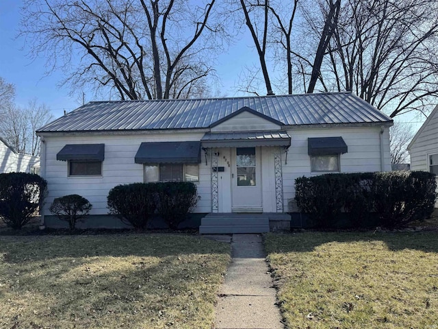 view of front of property featuring a front lawn and metal roof