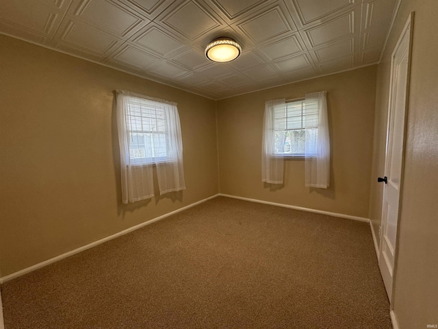 spare room featuring baseboards, an ornate ceiling, and carpet floors