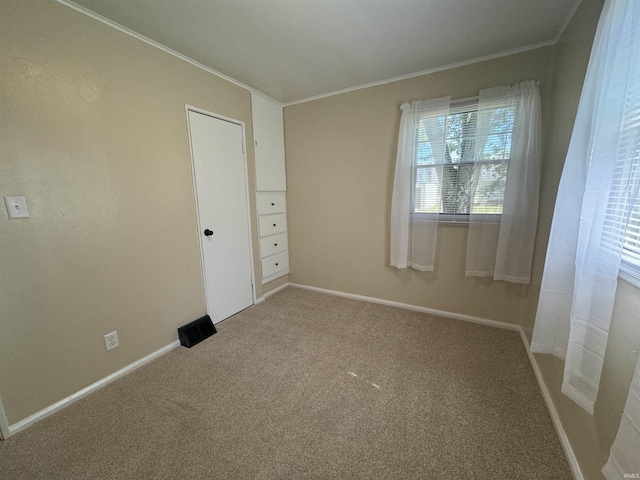 unfurnished bedroom with carpet flooring, baseboards, and crown molding