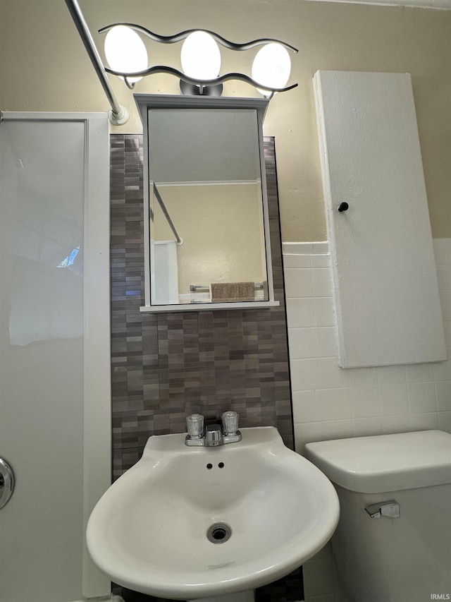 bathroom featuring a sink and tile walls