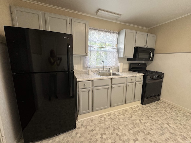 kitchen featuring light floors, light countertops, ornamental molding, black appliances, and a sink