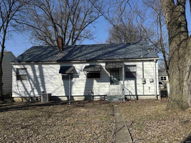 view of front of property featuring a chimney, cooling unit, metal roof, and entry steps