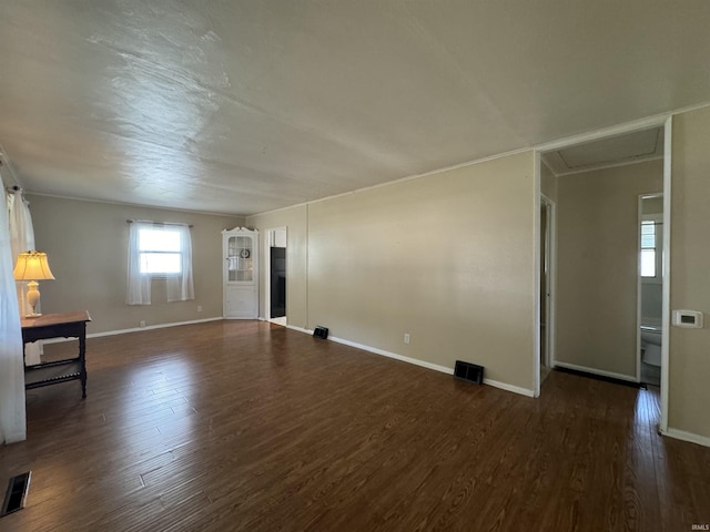 unfurnished living room with visible vents, wood finished floors, and baseboards