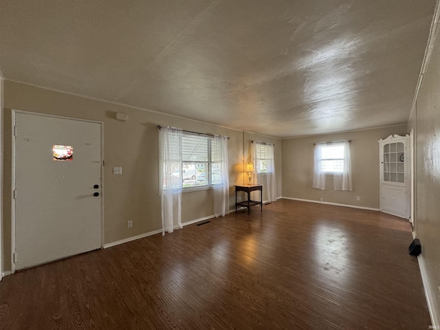 foyer entrance featuring visible vents, baseboards, and wood finished floors