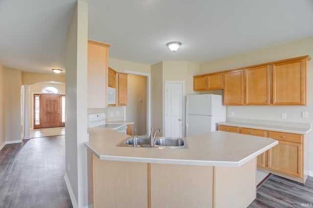 kitchen with a sink, white appliances, a peninsula, and light countertops