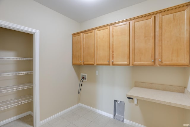 laundry area featuring washer hookup, light tile patterned flooring, cabinet space, and baseboards