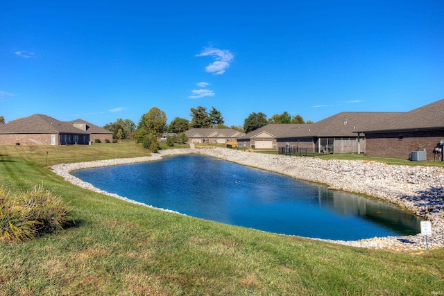 view of swimming pool with a yard and a water view