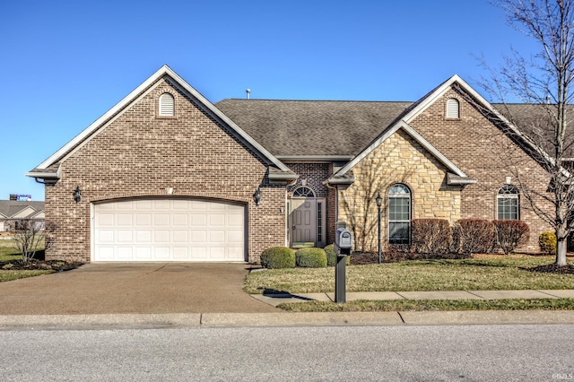 view of front facade with concrete driveway, an attached garage, brick siding, and roof with shingles