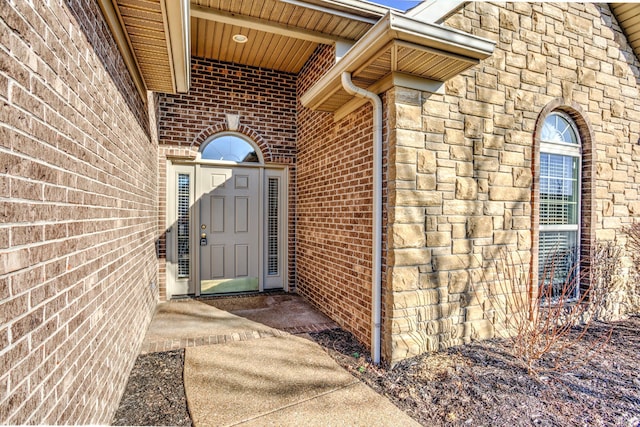 property entrance with stone siding and brick siding