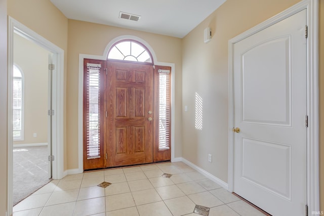 foyer with light tile patterned floors, visible vents, and baseboards