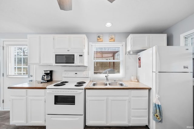 kitchen with a sink, white cabinetry, white appliances, light countertops, and decorative backsplash