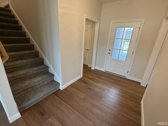 interior space featuring stairway, dark wood-type flooring, and baseboards