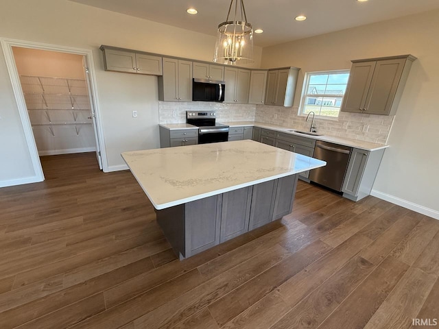 kitchen with decorative backsplash, appliances with stainless steel finishes, gray cabinetry, and a sink