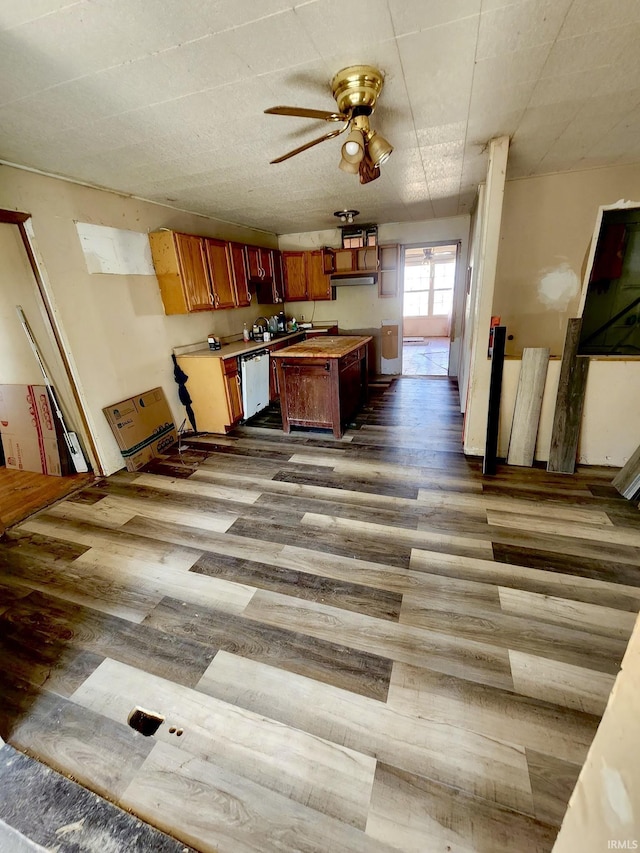 kitchen with wood finished floors, a center island, light countertops, dishwasher, and ceiling fan