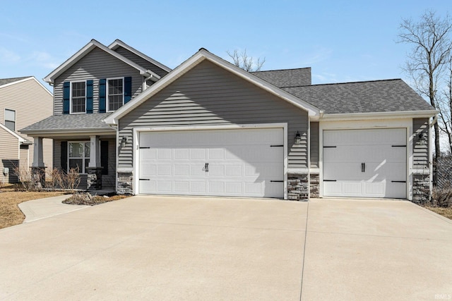 view of front of property with stone siding, driveway, and a garage