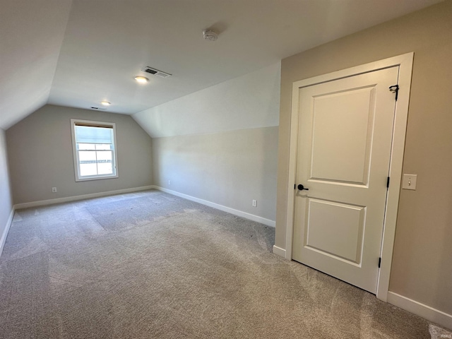 additional living space with vaulted ceiling, baseboards, visible vents, and carpet floors