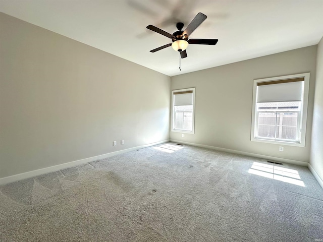 spare room featuring a ceiling fan, baseboards, visible vents, and carpet floors