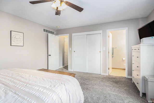 carpeted bedroom with visible vents, baseboards, ceiling fan, a closet, and ensuite bath