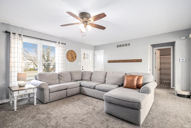 living room with visible vents, carpet, and a ceiling fan