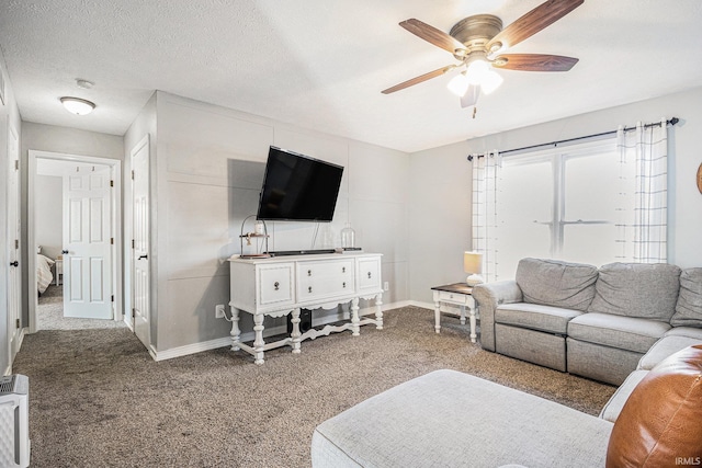 living room featuring baseboards, carpet flooring, a textured ceiling, and a ceiling fan