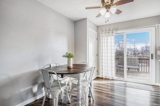 dining room featuring a textured ceiling, wood finished floors, baseboards, and ceiling fan