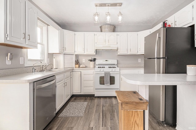 kitchen featuring under cabinet range hood, light countertops, appliances with stainless steel finishes, white cabinets, and a sink