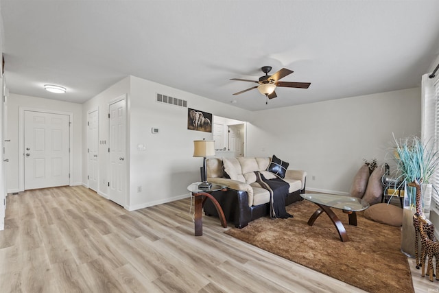 living area with visible vents, baseboards, a ceiling fan, and light wood finished floors