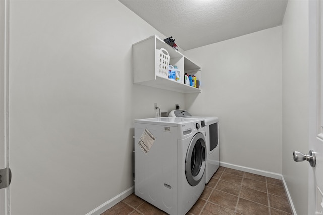 laundry area featuring baseboards, a textured ceiling, laundry area, and washing machine and clothes dryer