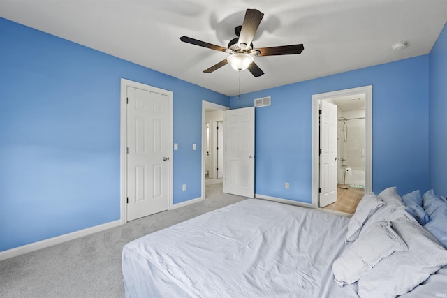 bedroom featuring carpet, visible vents, baseboards, ceiling fan, and ensuite bathroom