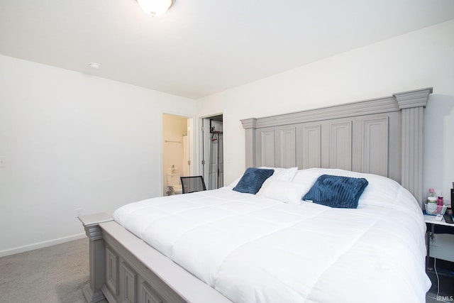 bedroom featuring ensuite bath, baseboards, and light carpet