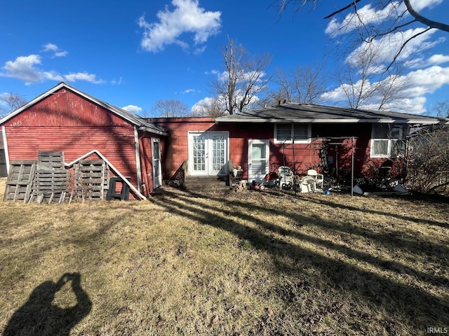 rear view of house with french doors and a yard