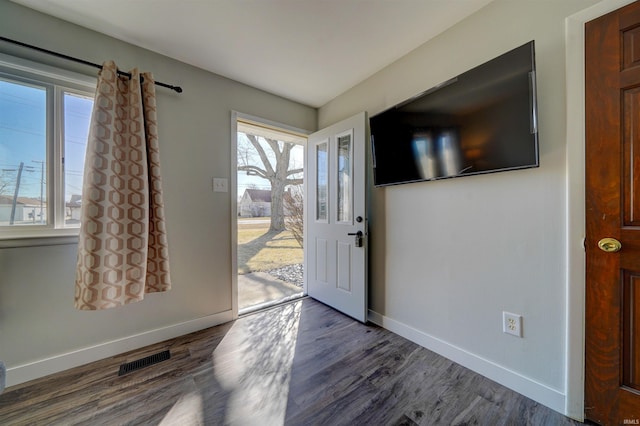 foyer featuring visible vents, dark wood-type flooring, and baseboards