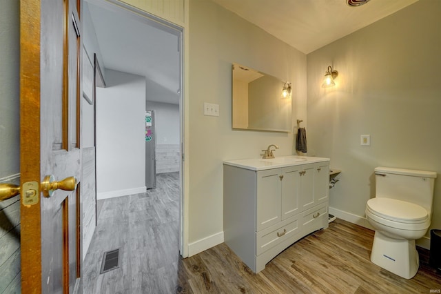 bathroom with visible vents, baseboards, toilet, and wood finished floors