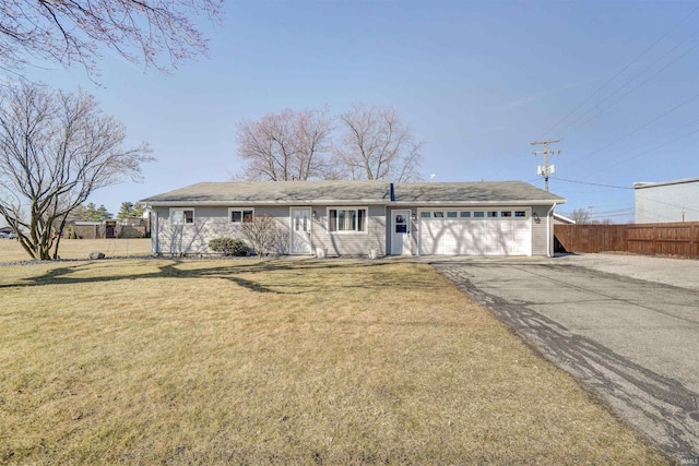 ranch-style house featuring a front lawn, an attached garage, fence, and driveway