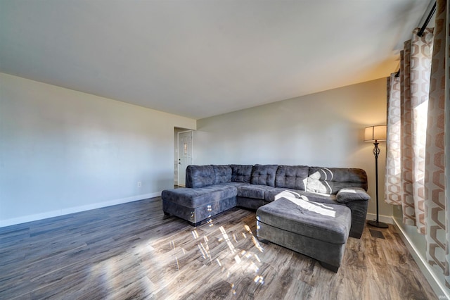 living area with baseboards and wood finished floors